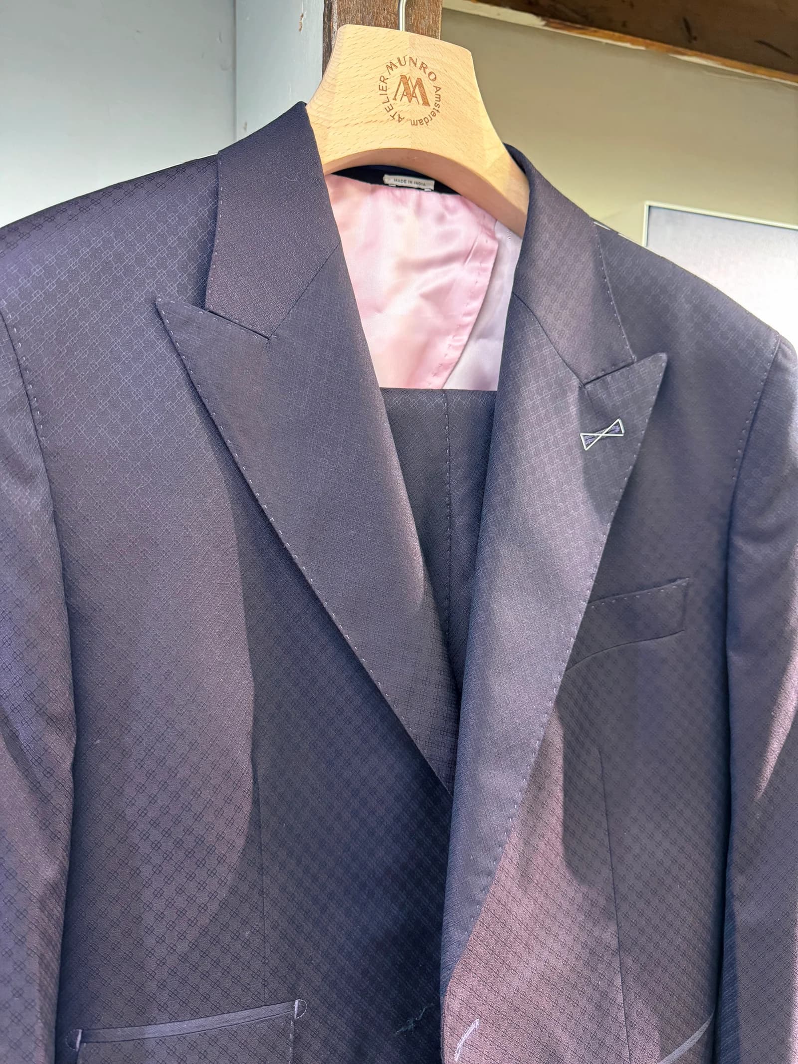 Actual blue-violet garment photographed in the shop, showing woven cloth and blush lining
